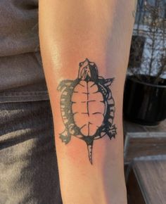 a small turtle tattoo on the arm