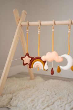 a baby crib with wooden toys hanging from it's sides and a white rug on the floor