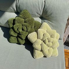 two towels are laying on the back of a couch next to a flower shaped towel