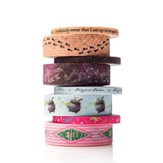 five different colored washi tapes stacked on top of each other, with words printed on them