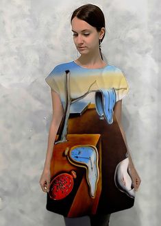 a woman standing in front of a wall with a painting on it's back