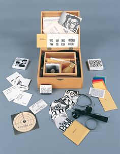 an open wooden box containing various items including scissors, cards, and other personal items