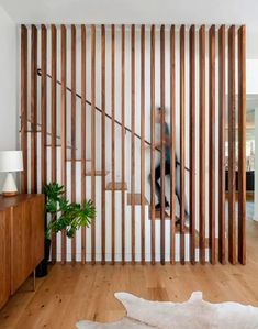 a living room with wooden slats on the wall and a plant next to it