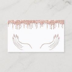 a white business card with pink and gold foil paint drips on the top of it