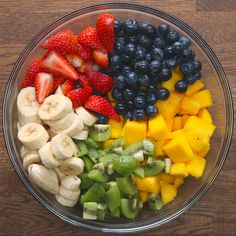 a bowl filled with fruits and vegetables on top of a wooden table