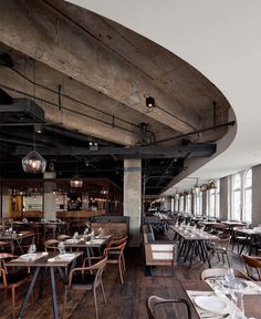 an empty restaurant with tables and chairs in the center, along with wooden flooring