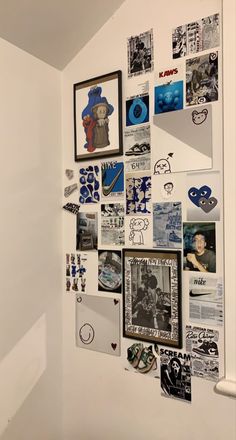 a white wall covered in pictures and magnets