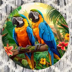 two colorful parrots sitting on a tree branch in the jungle with tropical flowers and leaves