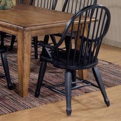 a dining room table with two chairs and a rug