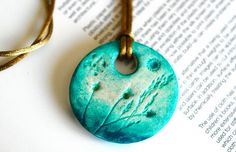 a close up of a book with a necklace on it's end and an open book in the background