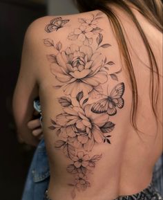 a woman's back with flowers and butterflies on it