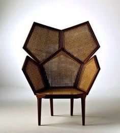 a chair made out of wood and wicker with four sections on each side, sitting in front of a white background