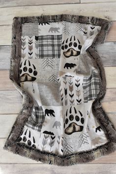 an animal themed blanket on a wooden floor