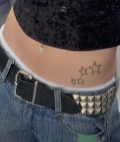 a woman's stomach with three stars tattooed on the bottom of her belly,