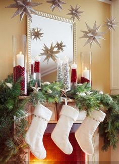 christmas stockings hanging from a mantle with candles