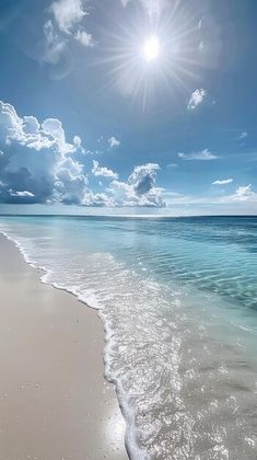 the sun shines brightly over an ocean beach with white sand and clear blue water