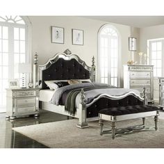 a bedroom with white and silver furniture in the room, including a large bed frame