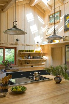 a kitchen with wood paneling and lots of counter space next to an open window