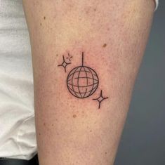 a woman's arm with a small globe tattoo on it