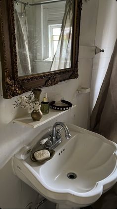 a white sink sitting under a mirror in a bathroom