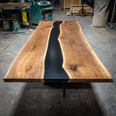 a table made out of wood and black eperform on the top, in a workshop