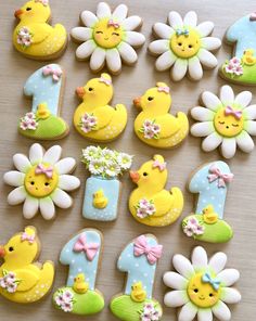 decorated cookies with numbers and flowers are arranged in the shape of ducks, daisies, and chicks