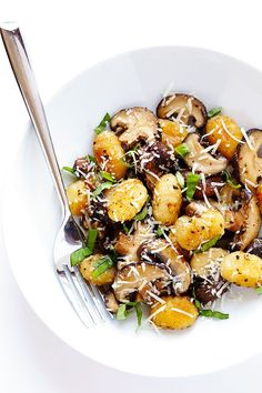 two white bowls filled with food on top of a table