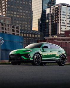 a green sports car parked in front of some tall buildings with skyscrapers behind it