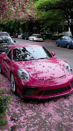 a pink sports car parked on the side of the road