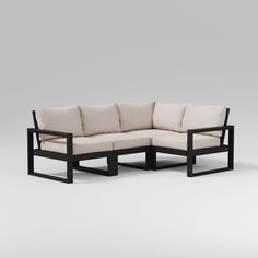 a black and white couch sitting on top of a gray floor next to a wooden frame