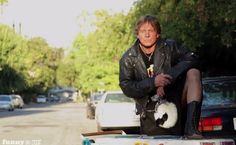 a man sitting on the back of a truck with his feet up in the trunk