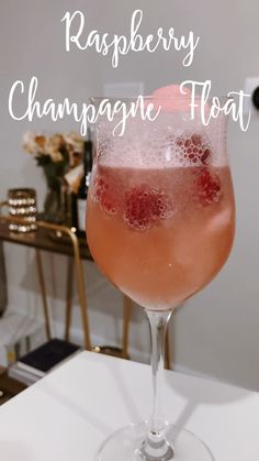 raspberry champagne float in a wine glass with the words raspberry champagne float above it