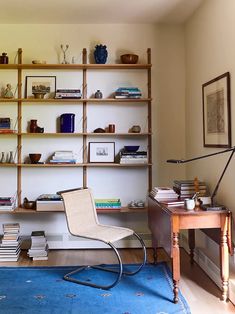 a room with a chair, bookshelf and other items on the shelves in it