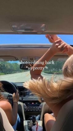 two women sitting in the back seat of a car, one is holding her hand up