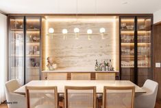 a dining room table and chairs in front of a bar