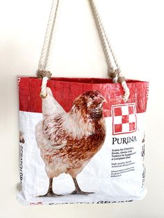 a red and white shopping bag with a chicken on it's side hanging from a hook