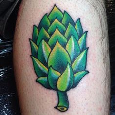 a tattoo on the leg of a man with an artichoke in green and yellow