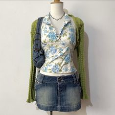 a mannequin is dressed up as a flowered shirt and jean skirt with suspenders