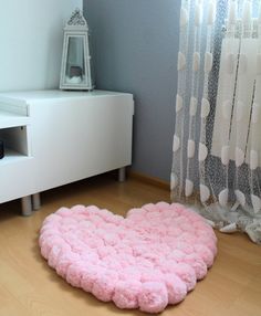 a pink heart shaped rug on the floor