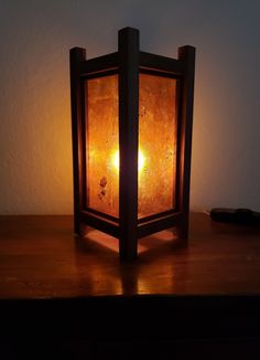 "This beautifully handcrafted Craftsman style lamp is made of natural materials such as stone and wood. Constructed from walnut and amber mica, its design is inspired by traditional Japanese lanterns.  The lantern exudes an inviting amber glow which provides a perfectly relaxing ambiance. This timeless lamp will make an elegant addition to any room. Plus, this lamp comes with a dimmer so you can adjust the lighting to your liking. Dimensions: 12\"H x 5.5\"W x 5.5\" Dimmer included *Mica is a glimmering mineral that's found in granite. It has a distinctive texture and reflective quality and its patterns are unique to each individual piece. *All-natural wood products are unique! Keep in mind that no piece of wood is exactly the same. There may be slight variations in the color, texture, and Shoji Lamp, Japanese Lamps, Stone And Wood, Japanese Lanterns, Style Japanese, Wood Lamps, Mission Style, Wood Products, Craftsman Style