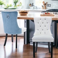 two blue and white chairs sitting in front of a kitchen island with wooden counter tops