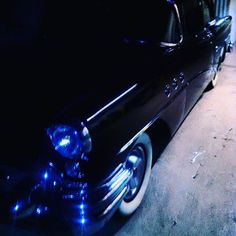 an old black car with blue lights on it