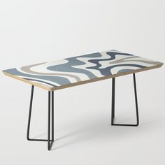 a wooden table with black metal legs and an abstract design on the top, against a white background