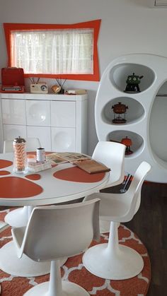 an orange and white dining room with modern furniture