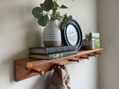 a couple of vases sitting on top of a wooden shelf next to a mirror