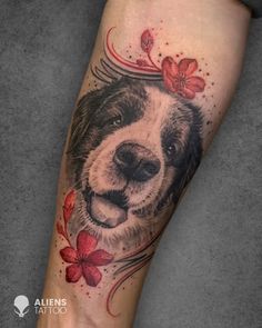 a black and white dog with red flowers on its head is shown in this tattoo