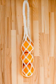 three oranges tied to a string on a wooden floor