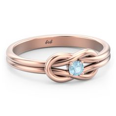 a rose gold ring with an aqua blue topazte stone in the center and a diamond