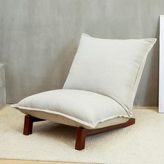 a white chair sitting on top of a rug next to a wall