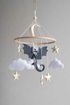 a baby mobile with a dragon and stars hanging from it's centerpieces